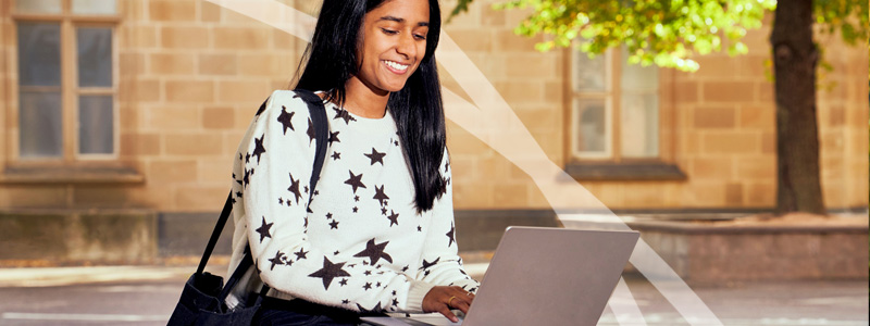student in courtyard with laptop