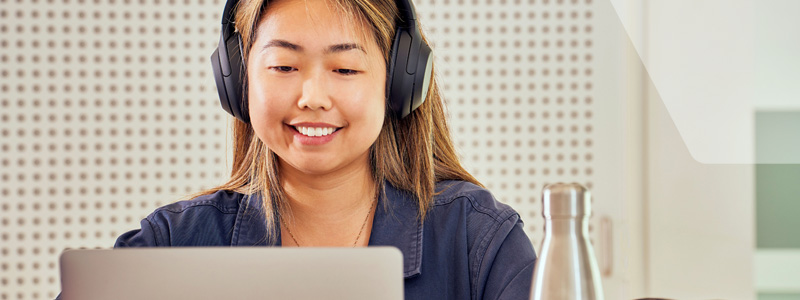 student at desk with headphones
